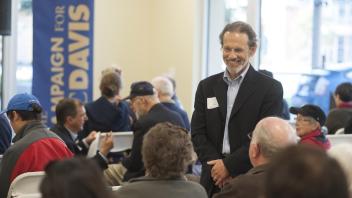 Image of Bob Segar interacting with university donors at a fundraising event.