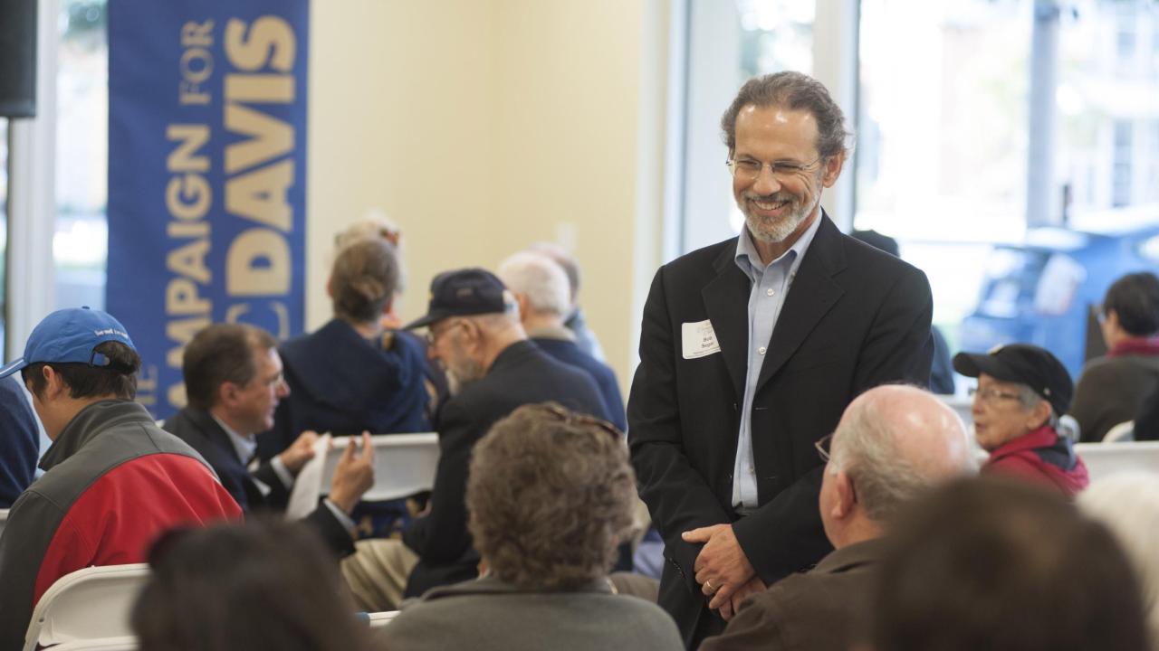 Image of Bob Segar interacting with university donors at a fundraising event.
